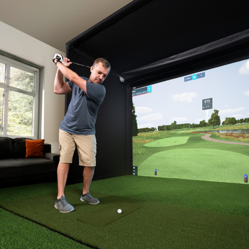 Carl&#39;s Place C-Series Pro Golf Simulator Enclosure Package with golfer hitting a ball.