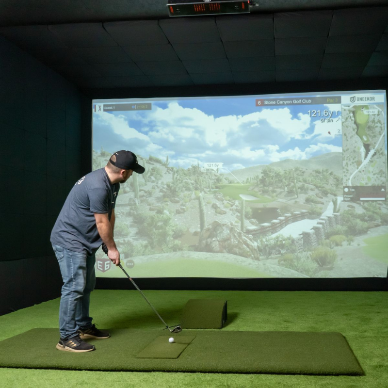 Carl&#39;s Place Floor Mounted Projector Enclosure with golfer in simulator.