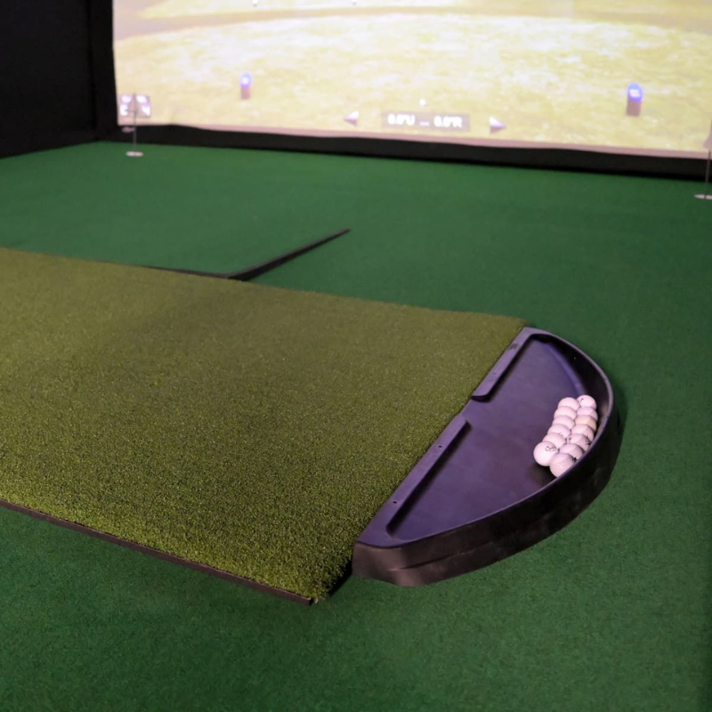 Carl&#39;s Place Golf Ball Tray inside golf simulator with mat and balls.