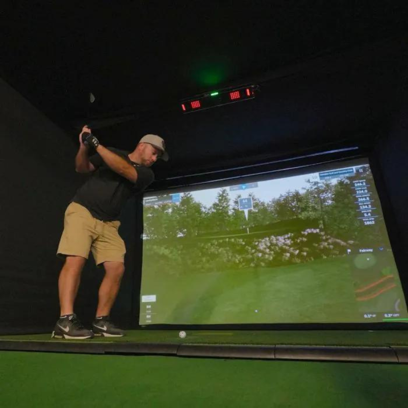 Carl&#39;s Place Uneekor EYE XO2 Protective Case installed in golf simulator with golfer swinging.