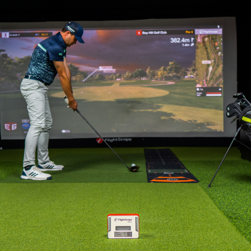 FlightScope Mevo+ Launch Monitor with golfer in a simulator.