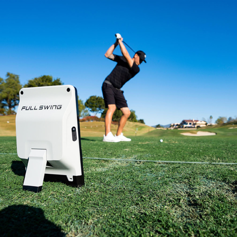Full Swing KIT Launch Monitor on a driving range with golfer.