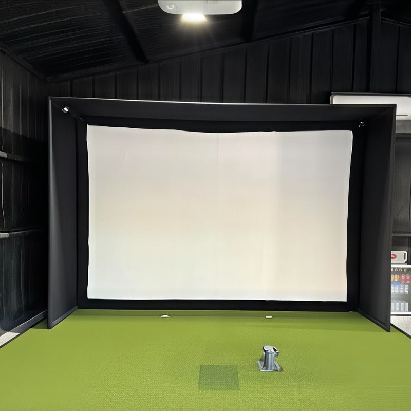Golf Simulator Installation by Indoor Golf Outlet: a finished enclosure and hitting mat inside a dark-walled shop building.