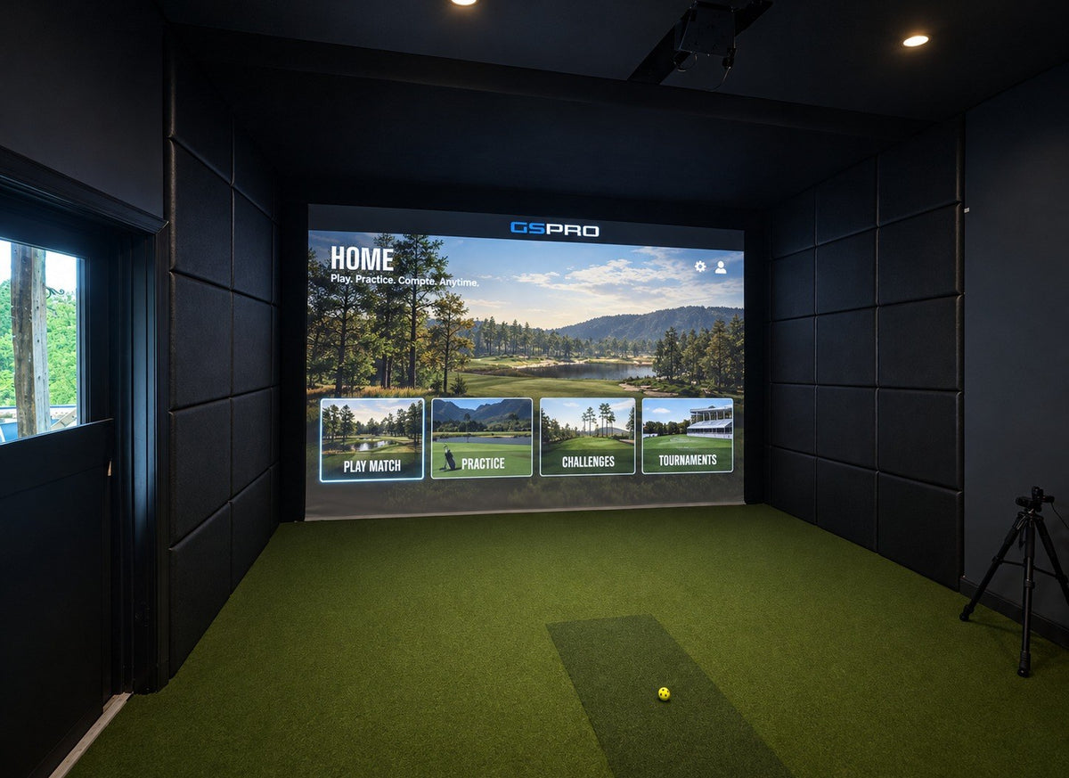 Finished golf simulator room with padded walls, a built-in impact screen and GSPro on screen