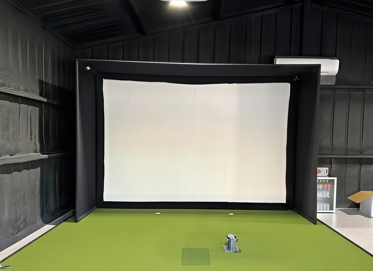 Finished golf simulator enclosure inside a dark-walled shop building