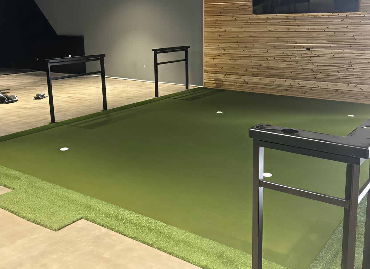 Large turf floor with putting cups, railings and a wood accent wall