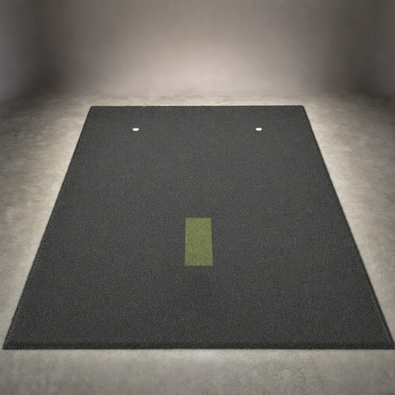 IGO Single-Level Golf Simulator Flooring in black laid out in a studio, with the green IGO Local Muni Hitting Strip set flush in the turf and two putting cups.