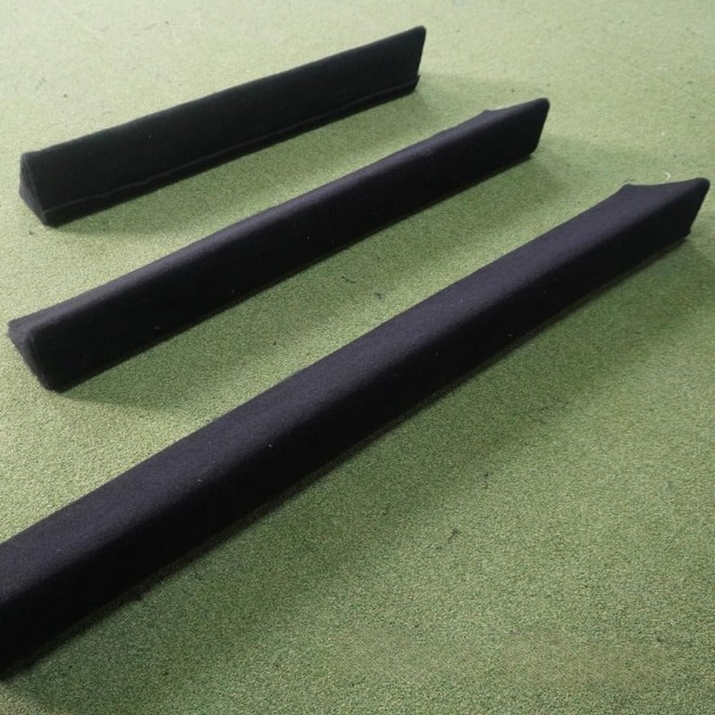 Impact Sports Ball Return Enclosure Bumper three black triangular bumpers laid on turf.
