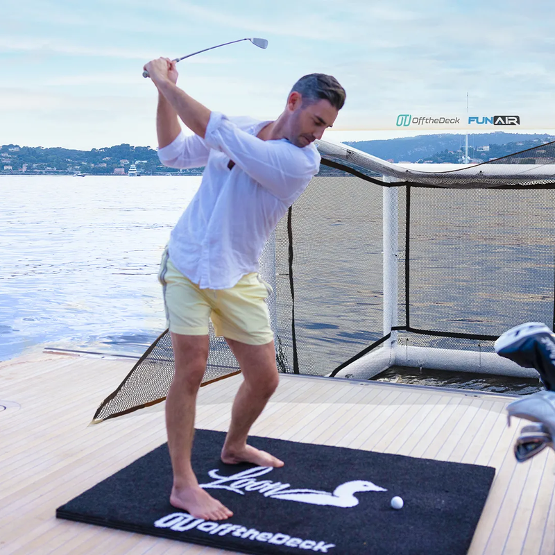 Off the Deck Cube Inflatable Golf Practice Net in use as a golfer hits from a yacht swim platform.