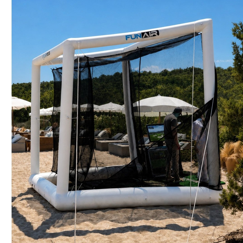 Off the Deck Cube Inflatable Golf Practice Net side view on sand showing the guy line and anchor holding the net in place.