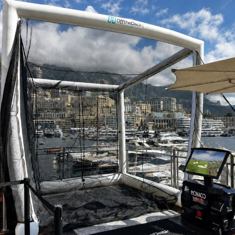 Off the Deck Cube Inflatable Golf Practice Net on a yacht sundeck overlooking a marina, with the hitting station in front of the net.