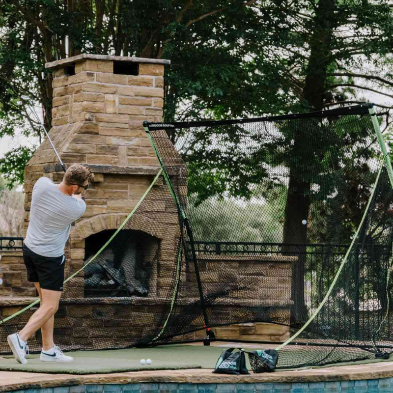 SIGPRO Golf Net with golfer and fireplace.