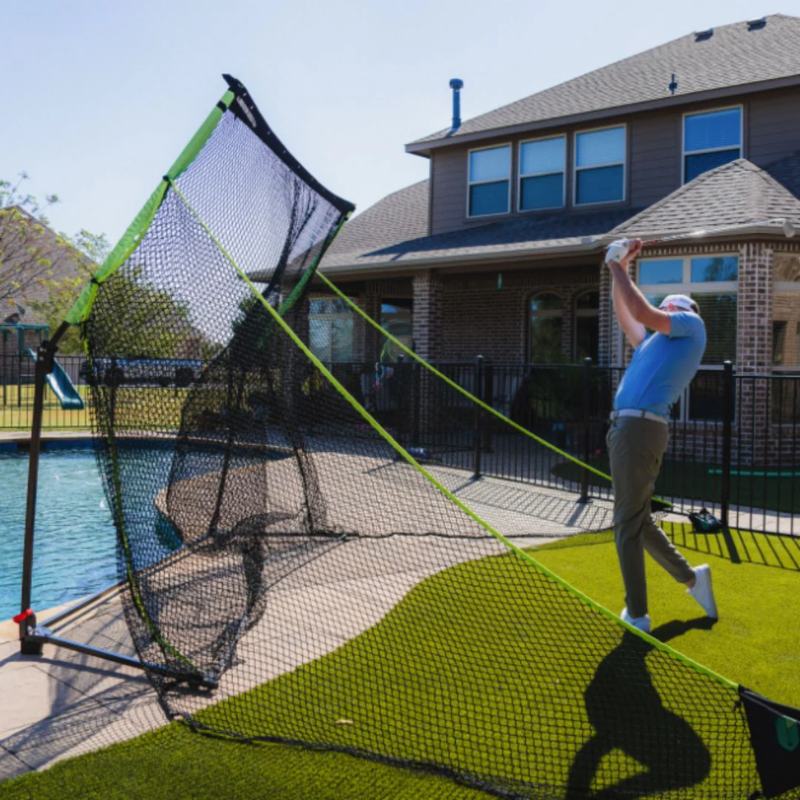 SIGPRO Golf Net in backyard with pool.