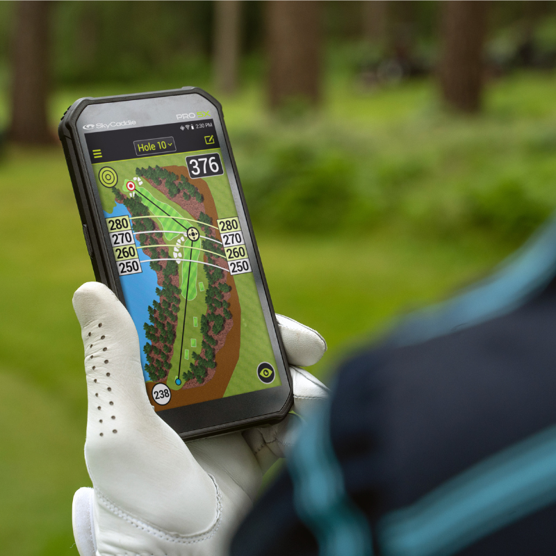 SkyCaddie PRO 5X handheld view with golf course in background.