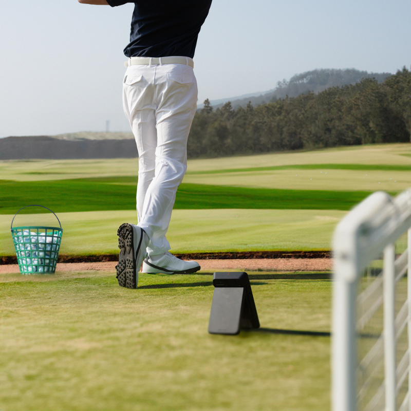 Swing Caddie SC4 Launch Monitor behind a golfer.