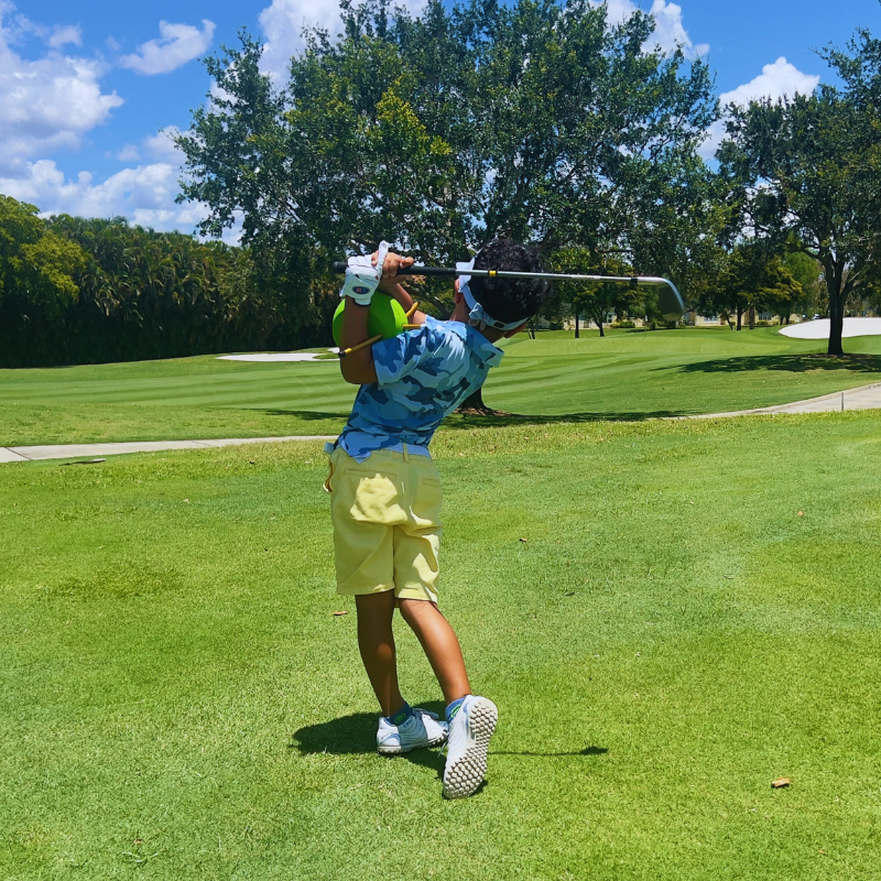 The Connector Jr. by Sure Golf with golfer in follow through position.