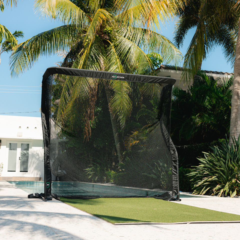 The Net Return Pro Series Golf Net with pool and house.