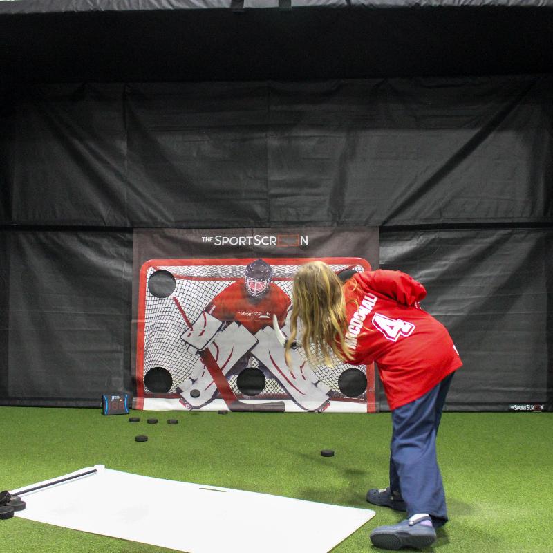 The SportScreen Parlour 16H Golf Simulator Enclosure kid shooting on hockey multisport attachment in parlour 16.