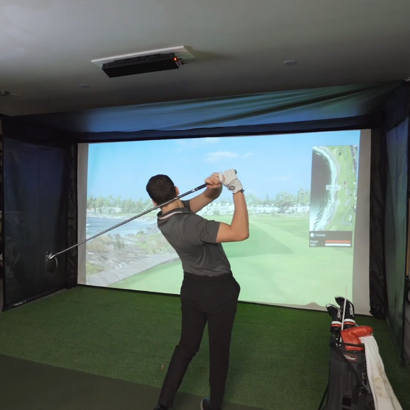 The SportScreen Vanish 16 Golf Simulator Enclosure man golfing.