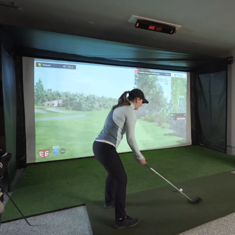 The SportScreen Vanish 16 Golf Simulator Enclosure women golfing.