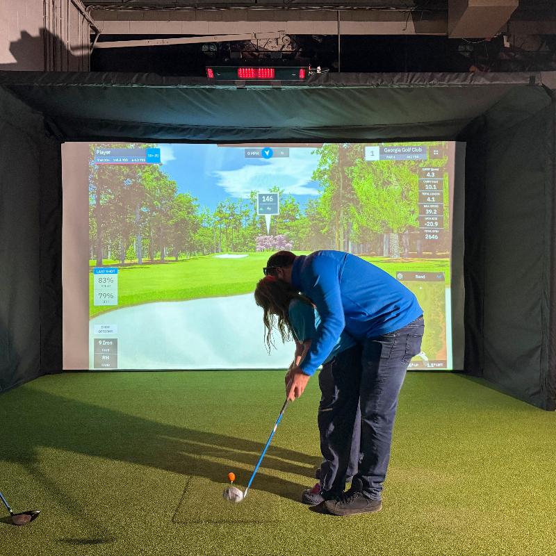 The SportsScreen Parlour Series Golf Simulator Enclosure father daughter golfing.