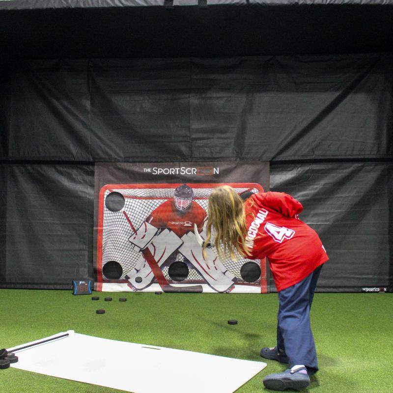 The SportsScreen Parlour Series Golf Simulator Enclosure kid shooting on hockey multisport attachment in parlour 16.