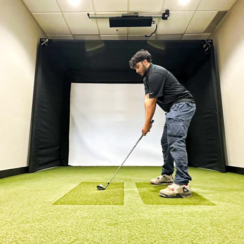 The SportsScreen Parlour Series Golf Simulator Enclosure low angle man golfing.