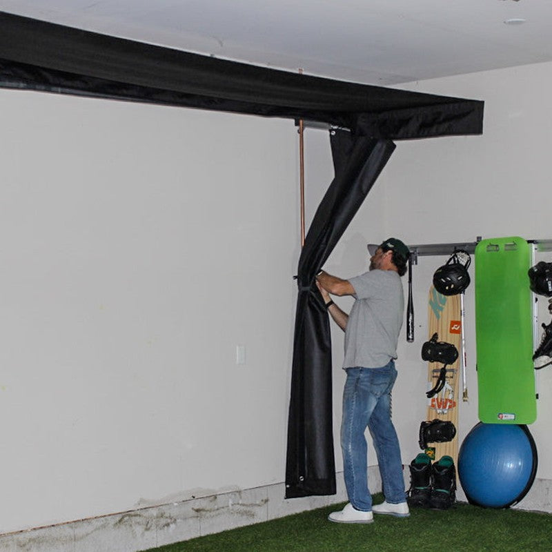 The SportsScreen Vanish LITE Series Golf Simulator Enclosure pinning side screens.