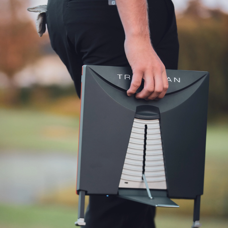 Trackman 4 Golf Launch Monitor person carrying device on golf course.