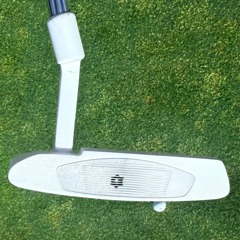Putter face coated with InkPact Micron showing a ball strike mark.